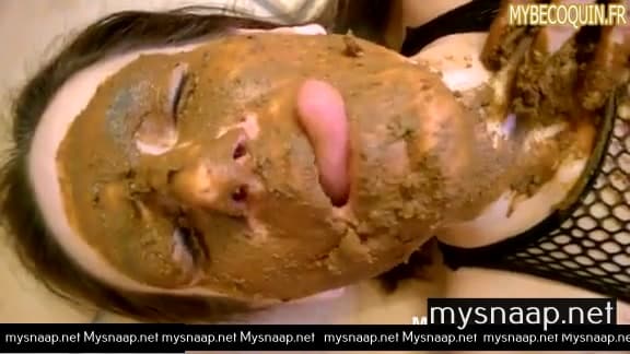 Femme couverte de merde mâche son excrément en jouant avec ses seins.