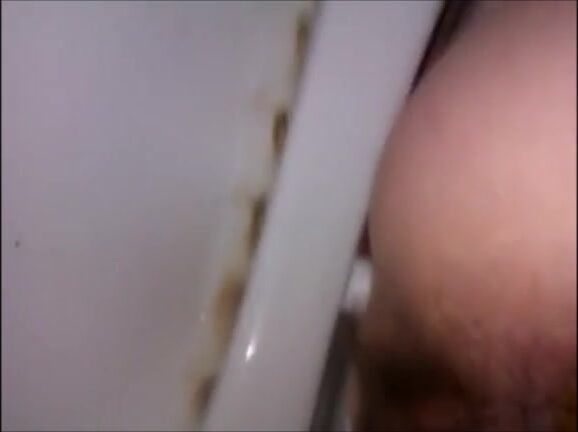 Hairy woman shitting in a dirty toilet closeup
